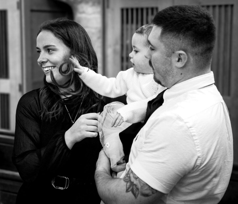 Parents holding their daughter at her christening, in black and white