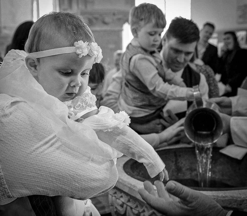 Water poured at the font during a christening, in black and white