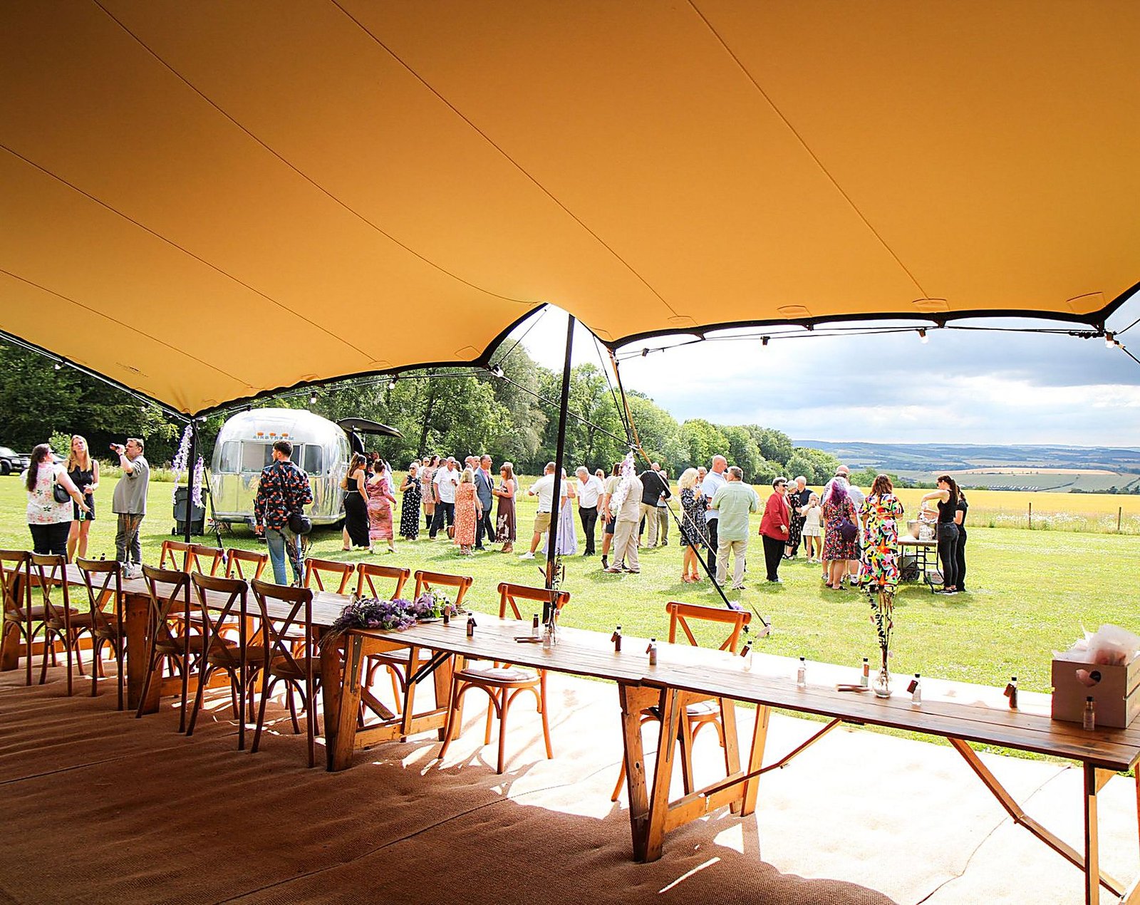 Outdoor tipi wedding reception in an Oxfordshire field
