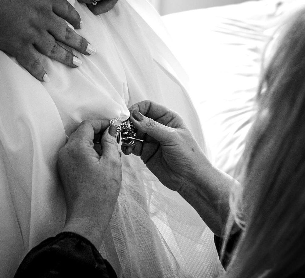 Final touches to the wedding dress before the ceremony, in black and white