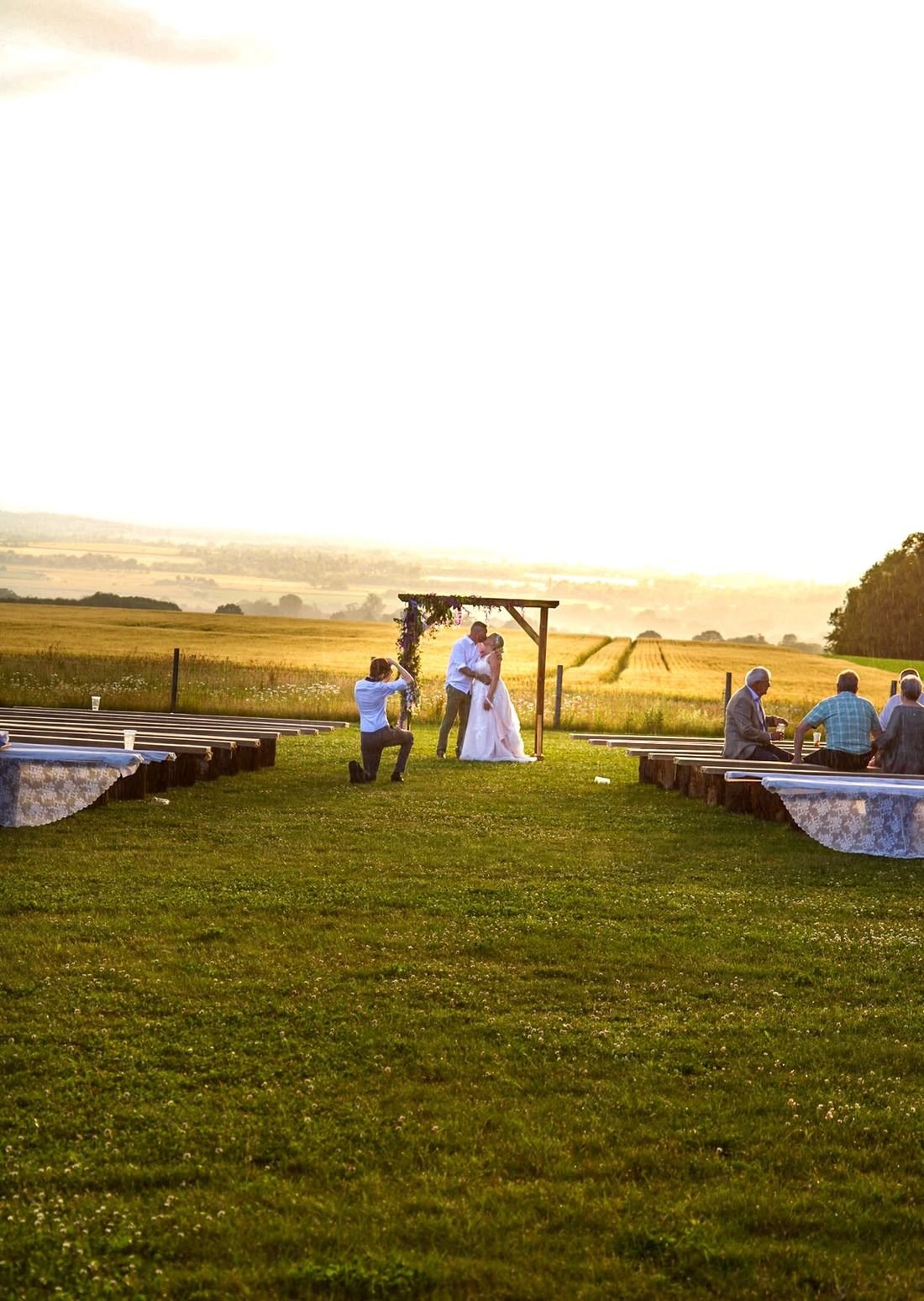 Wedding ceremony arch overlooking golden Oxfordshire fields at sunset